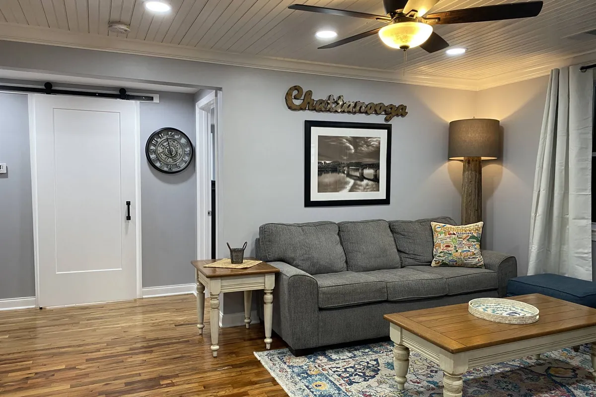 A warm, inviting sitting area with a plush sofa, coffee table, elegant wall art, and a floor lamp, all arranged to encourage conversation and shared moments. Decorative pillows add a playful touch, making the space both comfortable and family-friendly.